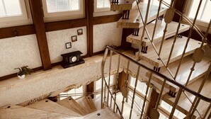 A wooden staircase with a metal railing, leading to multiple levels. - Adler Stube (Münstertal)
