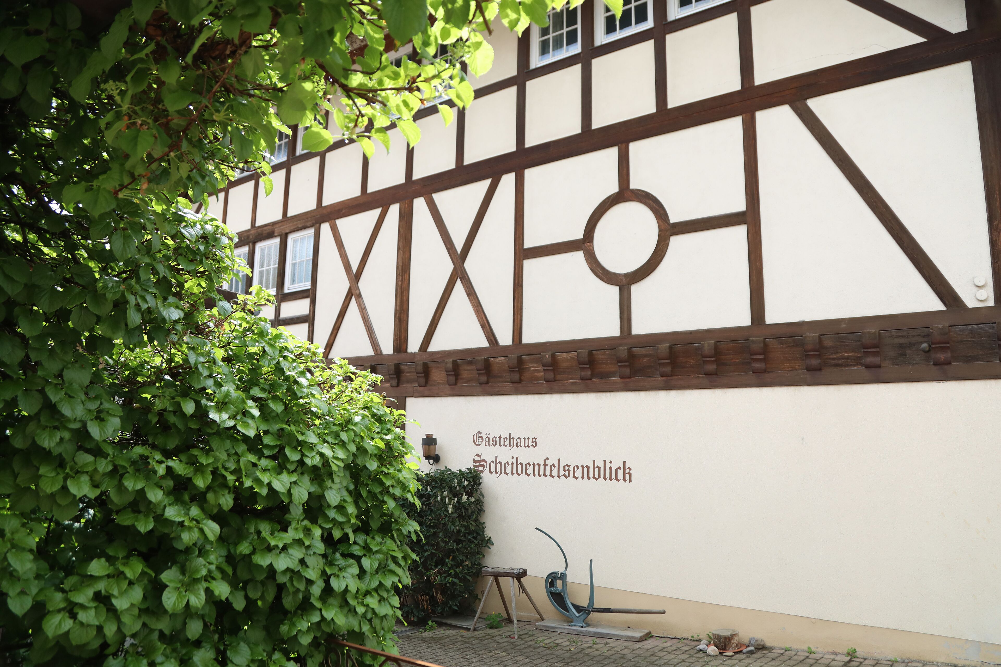 Un bâtiment traditionnel à colombages, sur lequel on peut lire l’inscription « Gästehaus Scheibenfelsenblick ».