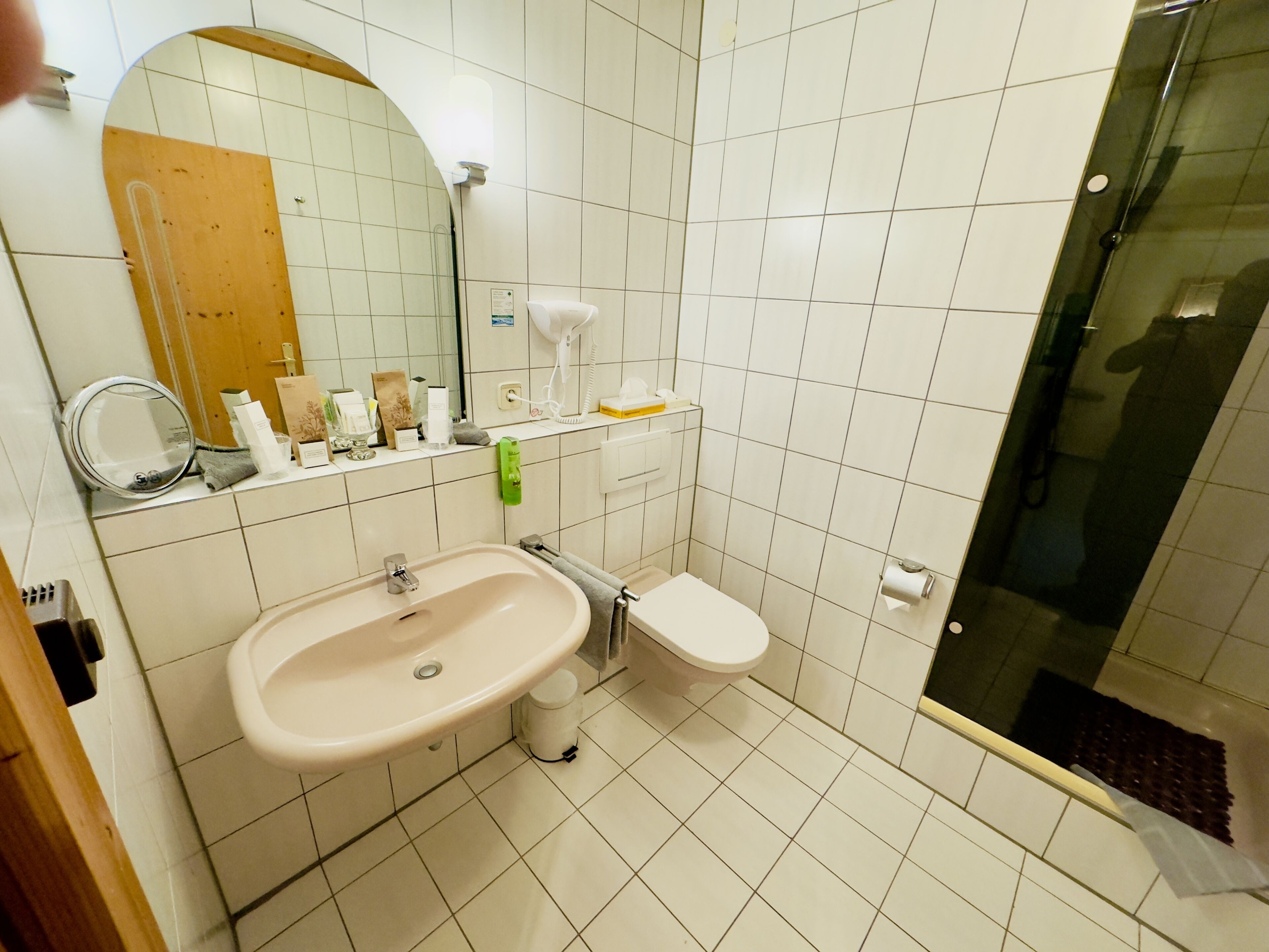Un baño con lavamanos, inodoro y cabina de ducha de vidrio.