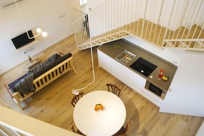 A modern kitchen with a dining area, wooden flooring, and a white staircase. - La Corte, Gallia by Theater Home, well furnished with lake view (Tignale)