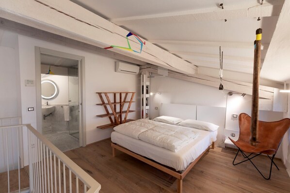 A bedroom with a wooden bed, a hanging chair, and a glass shower enclosure. - La Corte, Gallia by Theater Home, well furnished with lake view (Tignale)