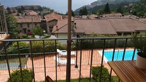 A balcony with a view of a swimming pool, a mountain, and a town. - Lince by Theater Home, with pool and lake view (Tignale)