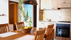 Een moderne keuken met houten kastjes, een eettafel met stoelen en een hanglamp.
