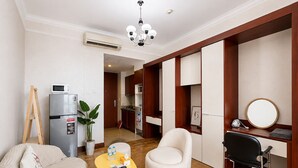 Un espace de vie compact comprenant un coin cuisine, un coin repas et un espace détente avec une table ronde et deux chaises.