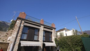 Ein Steinhaus mit Balkon, Schornstein und Satellitenschüssel.