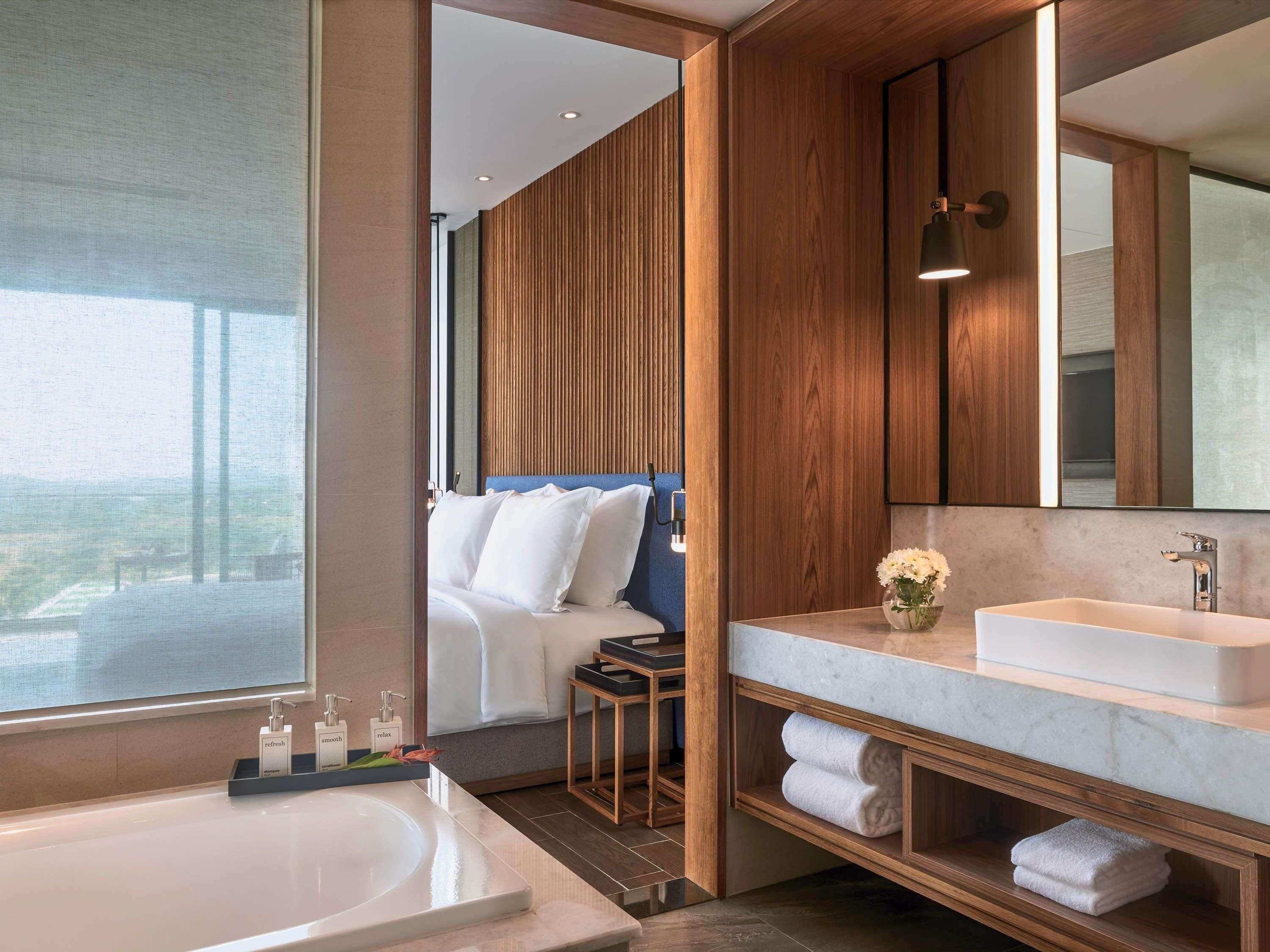 Une salle de bain moderne avec un grand lavabo, un miroir et un meuble-lavabo en bois.