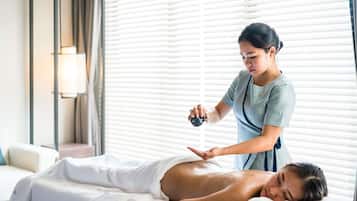 Sesión de masoterapia en una habitación con camilla, terapeuta y cliente.