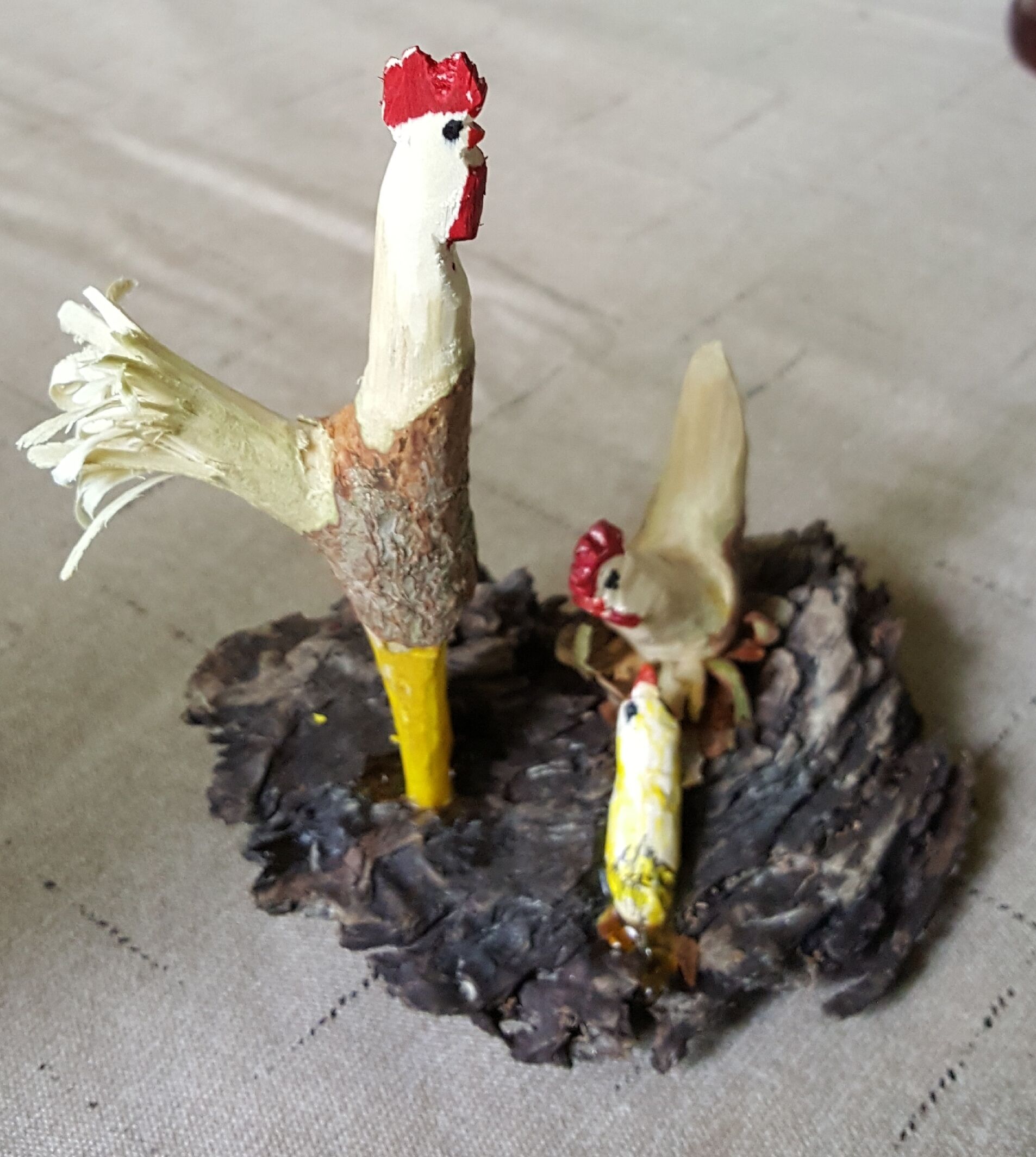 Dos modelos de pollo sobre una superficie oscura.
