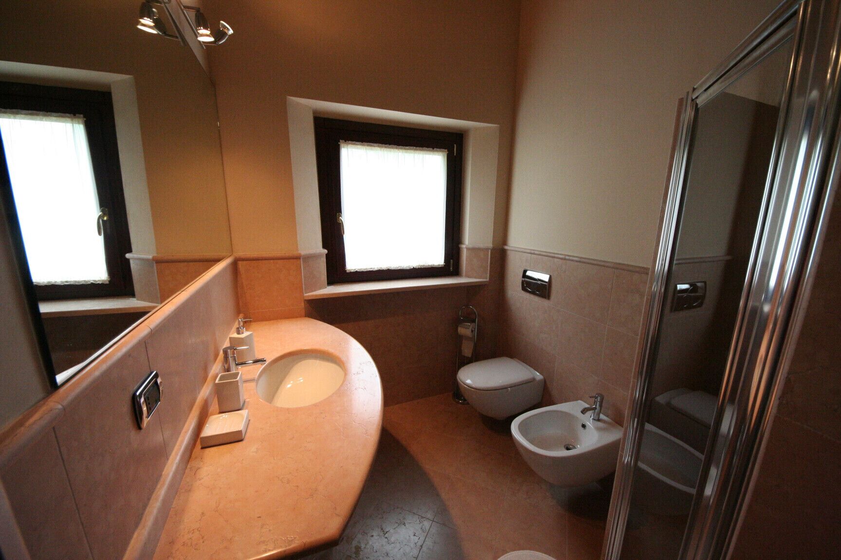 Une petite salle de bain comprenant un lavabo, des toilettes, un bidet et une petite fenêtre.