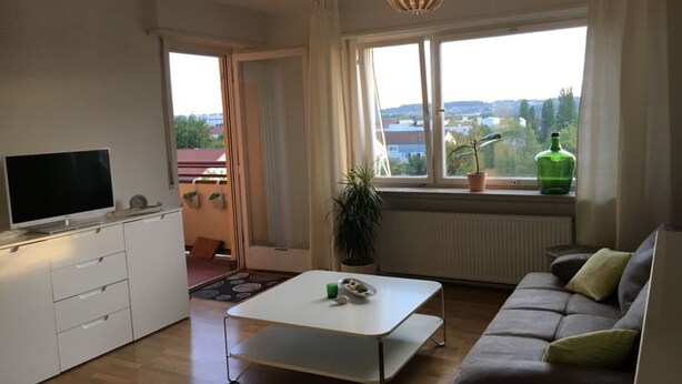 A modern living room with a sofa, a TV, and a dining table.