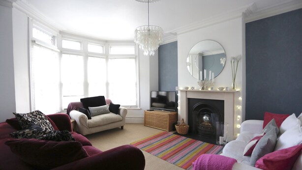 A living room with a fireplace, a television, and a large window. - Harrington House (Bristol)