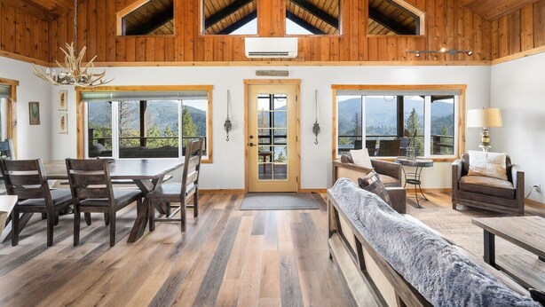 A spacious room with wooden beams, a large dining table, and a cozy seating area.