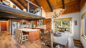 A spacious kitchen with wooden cabinetry, a large island, and a dining area with a bench.