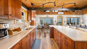 A spacious kitchen with wooden cabinets, a large island, and a dining area with a view.