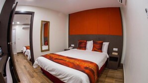 A hotel room with a large bed, a mirror, a bedside table, and a door leading to another room. - D'Spark Hotel Bayu Tinggi (Klang)