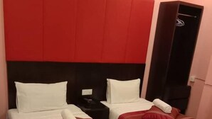 A hotel room with two beds, each with white bedding and red accents. There is a black headboard and a red accent wall. - D'Spark Hotel Bayu Tinggi (Klang)