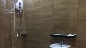 A small bathroom with a shower, a sink, and a mirror. - D'Spark Hotel Bayu Tinggi (Klang)