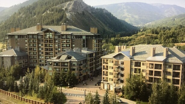 A multi-story hotel with a central courtyard, surrounded by trees and set against a backdrop of mountains. - Luxury One Bedroom Westin Riverfront Villa (Avon)