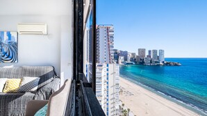 Un balcón con vistas a la playa y edificios altos.