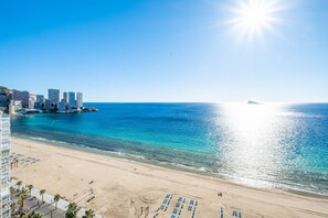 A beach with a cityscape in the background, a clear sky, and the sun shining. - Santa Margarita 14-D (Benidorm)