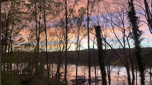 A lakeside view with dock structures and dense trees. - Quiet sunsets on Lanier (Oakwood)