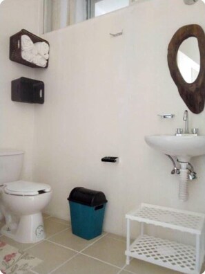 Bathroom with a toilet, sink, and mirror.