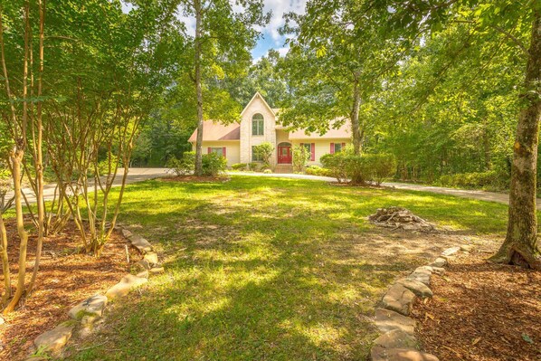 A house with a stone facade, a red door, and a small front porch.