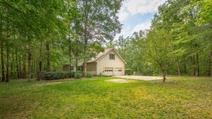 A single-story house with a garage, surrounded by a forested area. - 12 Bedroom XL HotTub 2 HOUSES~44ppl (Lookout Mountain)