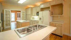 A modern kitchen with a central island, double sink, and built-in appliances. - 12 Bedroom XL HotTub 2 HOUSES~44ppl (Lookout Mountain)