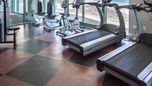 A gym with treadmills, stationary bikes, and weight machines, large windows with a view of the beach. - Relaxing Three Bedroom Unit at Turquoise Place Right on the Gulf of Mexico Beach (Orange Beach)