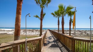 A wooden boardwalk leading to a beach with palm trees and a clear blue sky. - Relaxing Three Bedroom Unit at Turquoise Place Right on the Gulf of Mexico Beach (Orange Beach)