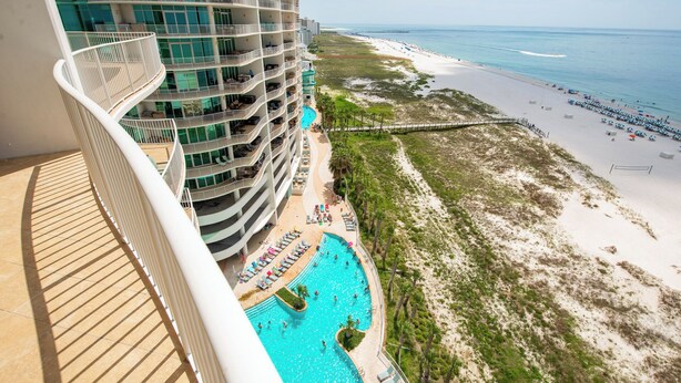 A high-rise hotel with multiple balconies overlooking a beach and a swimming pool. - Relaxing Three Bedroom Unit at Turquoise Place Right on the Gulf of Mexico Beach (Orange Beach)