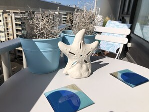 Een balkon met bloempotten en een wit decoratief object.