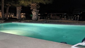 Une piscine bordée de palmiers et dotée d’une zone de détente.