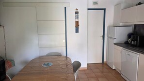 Una cocina compacta con refrigerador, cafetera y microondas.