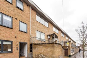 A multi-story brick building with a flat facade, large windows, and a visible entrance.