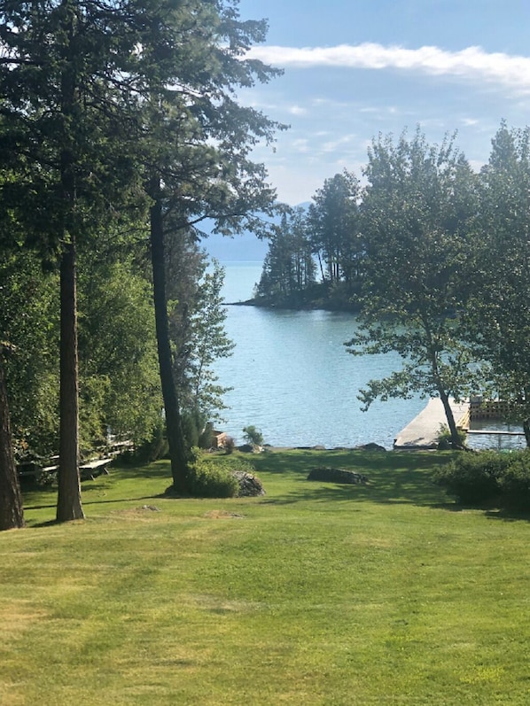 A grassy area with trees and a body of water in the background. - Eagle's Landings Lakeside Cabin (Lakeside)