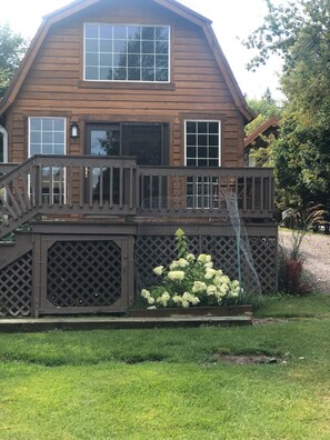 A two-story wooden house with a balcony and a covered porch. - Eagle's Landings Lakeside Cabin (Lakeside)