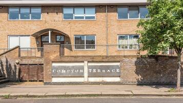 A two-story building with a brick facade, numbered '2' on the ground floor, and a sign reading 'COMPTON TERRACE' above the entrance.