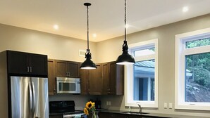 A modern kitchen with a central island, stainless steel appliances, and pendant lighting.