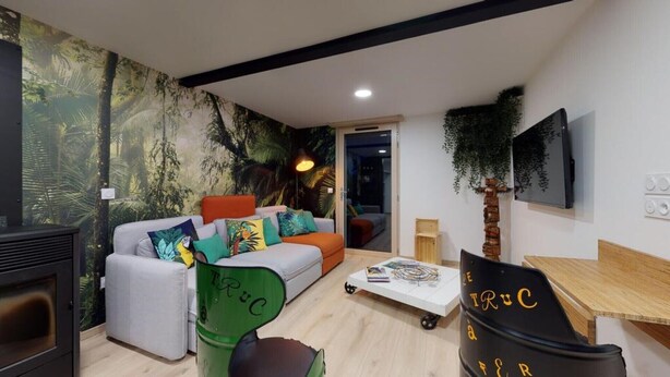 Ein modernes Wohnzimmer mit einer Couch, einem Couchtisch und einem an der Wand montierten Fernseher.