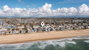 Luchtbeeld van een kustplaats met een strand, huizen en een waterpartij.