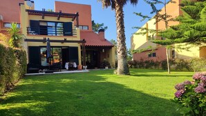 A modern two-story house with a covered patio and a well-maintained lawn.