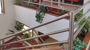 A multi-level interior with a staircase, a red sofa, and a bookshelf.