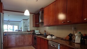 A kitchen with wooden cabinets, a stainless steel dishwasher, and a granite countertop.