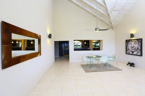 A spacious interior with a dining area, a large mirror, and artwork on the walls.