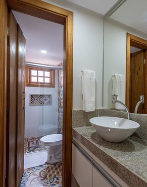 A bathroom with a white sink, a mirror, and a shower.