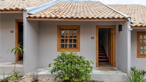 Een huis met een pannendak, een kleine voortuin en een trap naar de ingang.