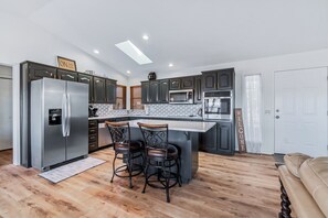 Prepare meals and socialize in this kitchen with a large island and bar stools.
