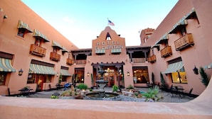 A hotel with a central fountain, outdoor seating, and a sign reading "HOTEL EL CAPITAN".